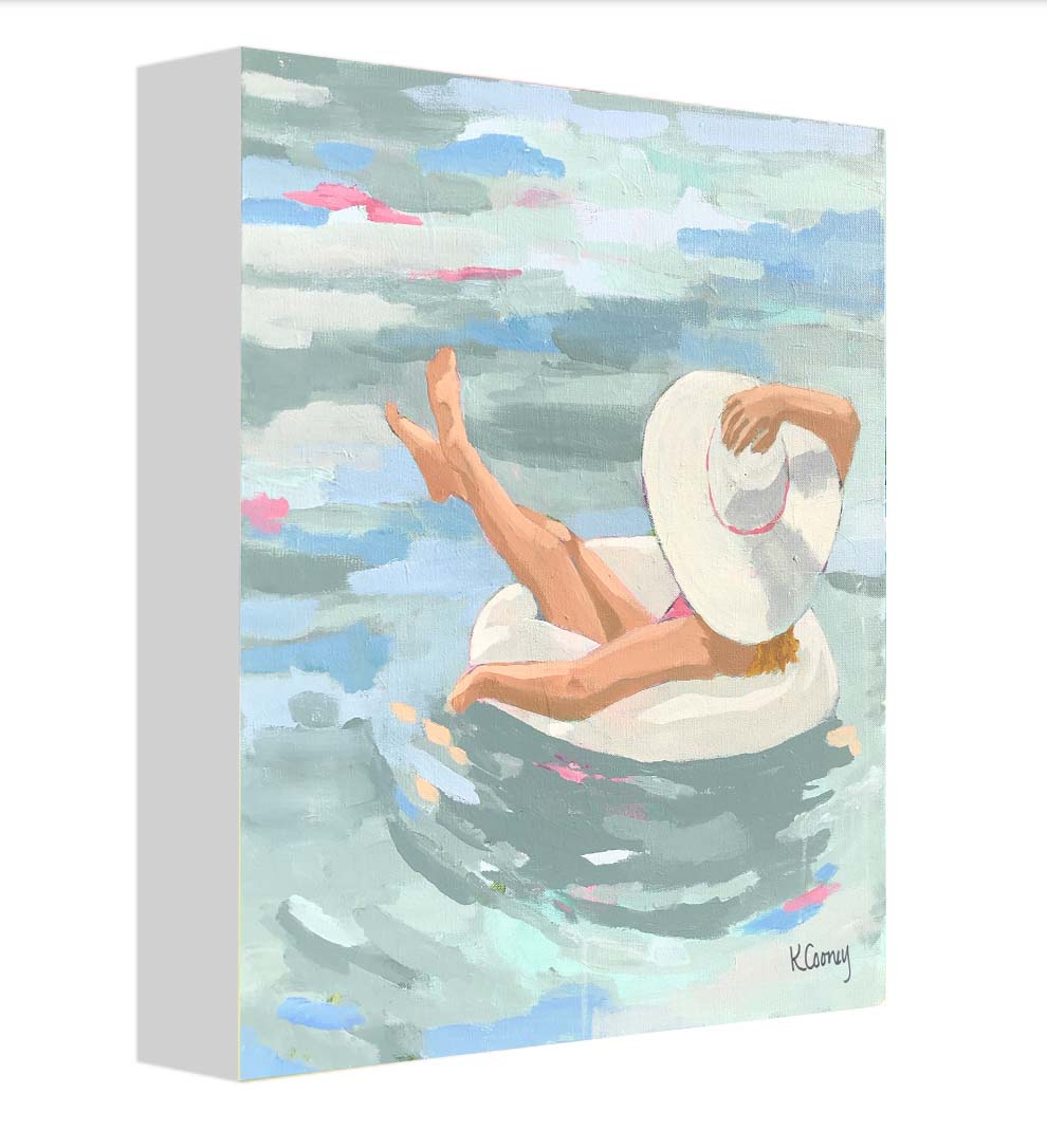 Kristin Cooney's fine art print from her Bathing Beauties collection, inspired by 1950's beach fashion and femininity. The HANNAH fine art print by Kristin Cooney—featuring a glamorous woman in a pink swimsuit and sunhat, gracefully lounging in a pool float. A nod to vintage glamour with free U.S. shipping and multiple size options. Created from an original painting by Kristin Cooney.