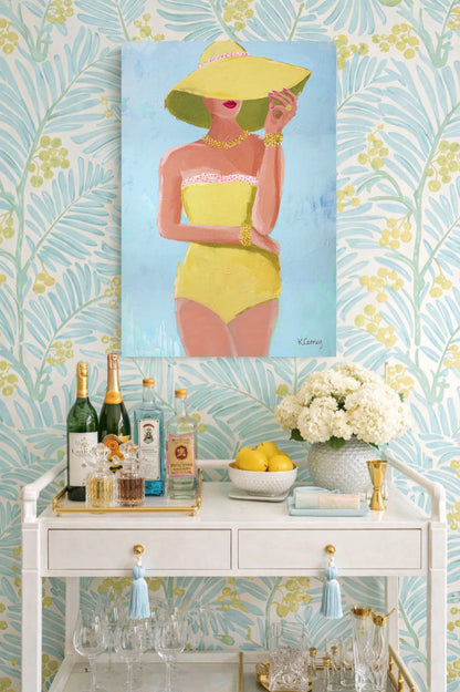 Decorative bar cart in Palm Beach with a painting of a glamorous woman in a yellow swimsuit on a blue background. 